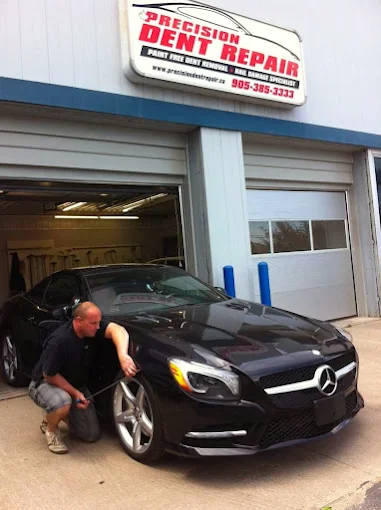 Paintless dent repair technician working a dent for a Hamilton customer