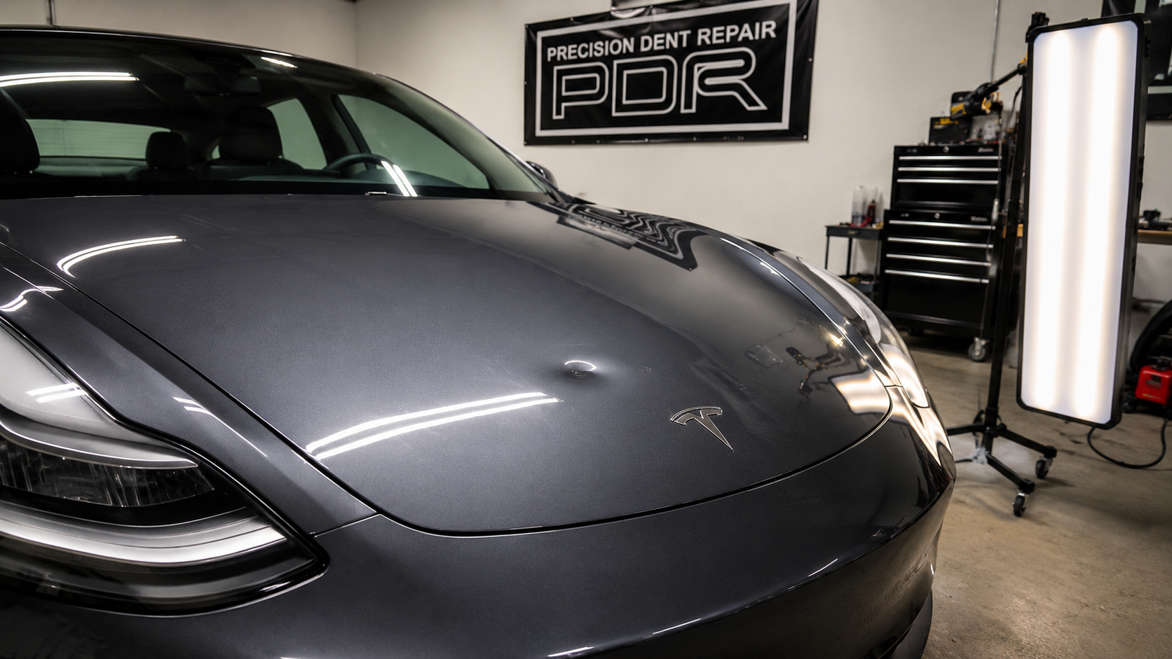 Tesla Model 3 hood — paintless dent repair before and after — before