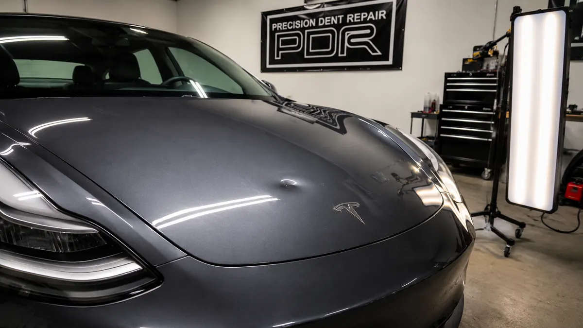 Tesla Model 3 hood — paintless dent repair before and after — before